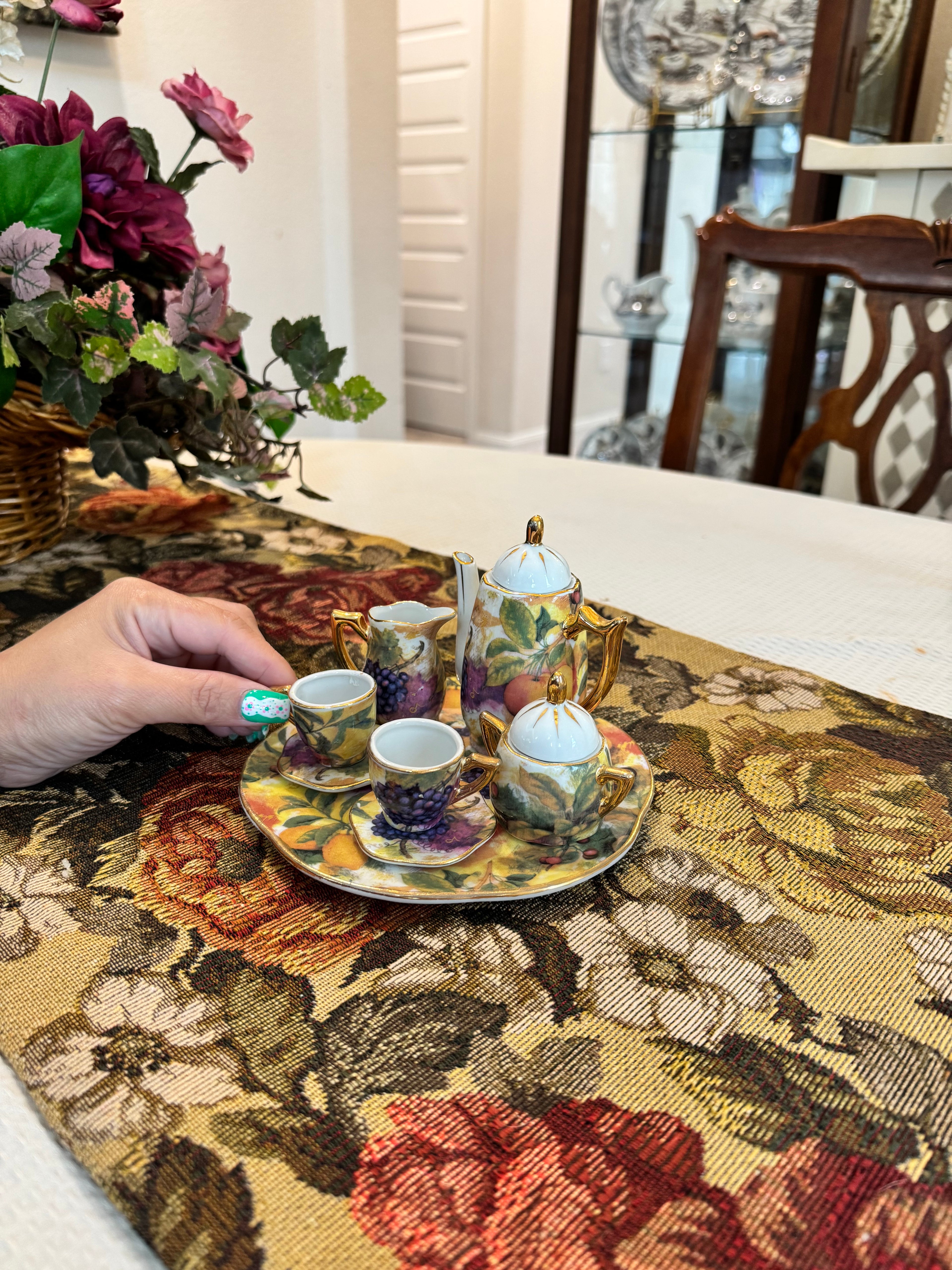 Vintage miniature porcelain tea set features a fruit motif pattern with gold gilt accents by Baum Bros Formalities.