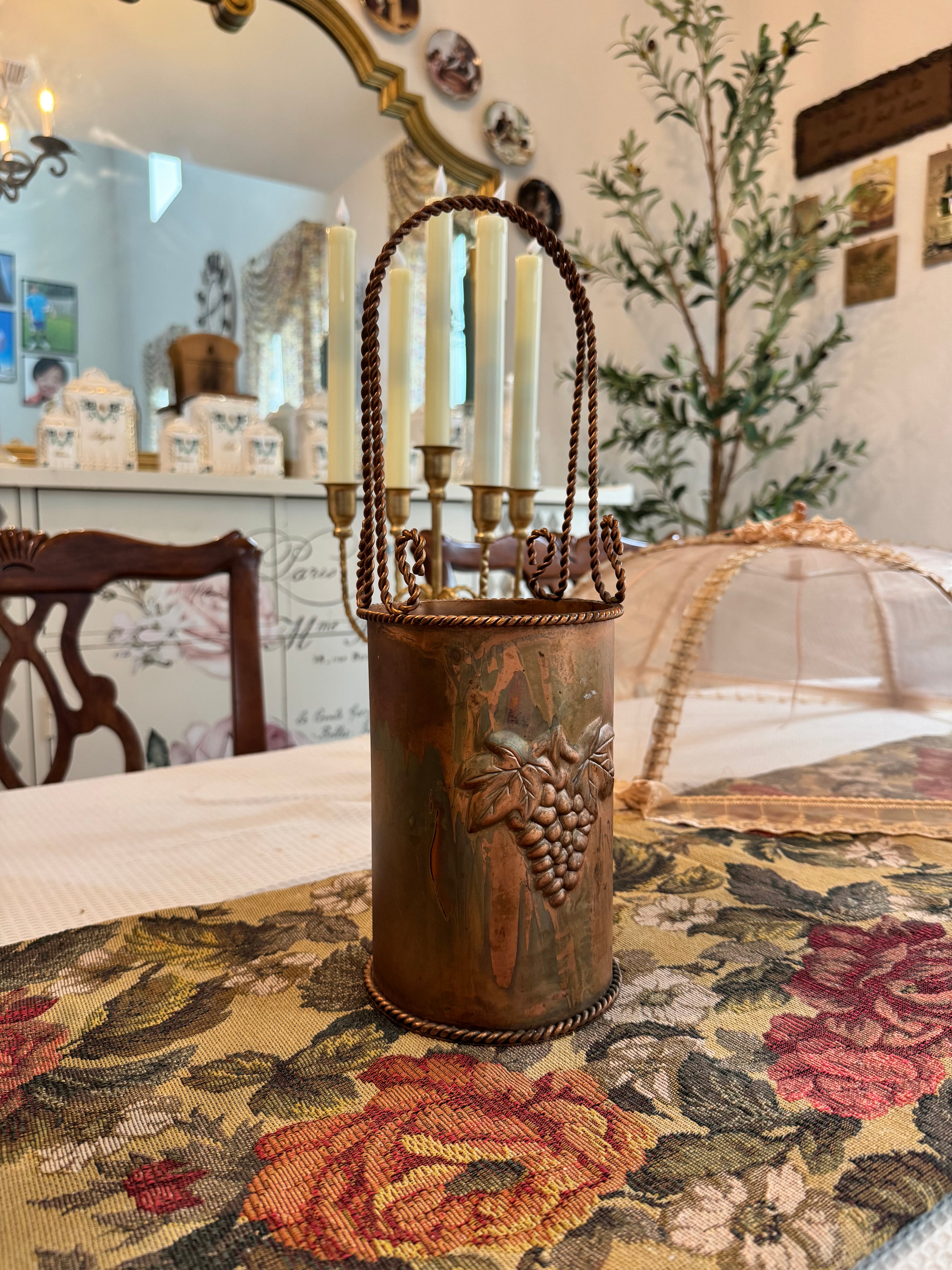 Vintage hammered copper wine or champagne cooler bucket with a twisted handle and grapevine embossing.