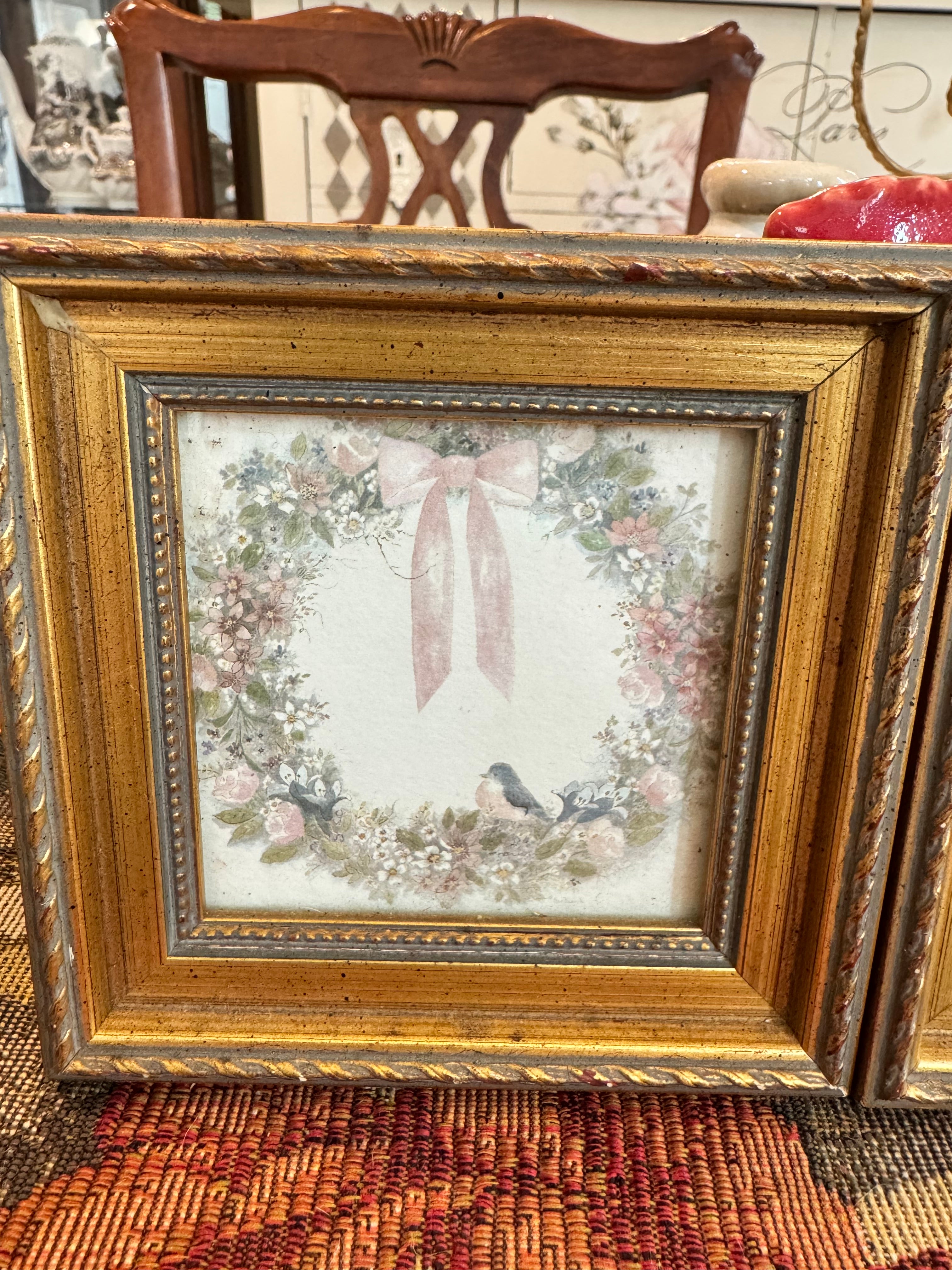 A pair of vintage framed prints by Homco with wreath and rosettes design by artist Bertrand