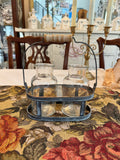 A pair of vintage inspired farmhouse style glass bottles in a galvanized metal container with a wooden handle