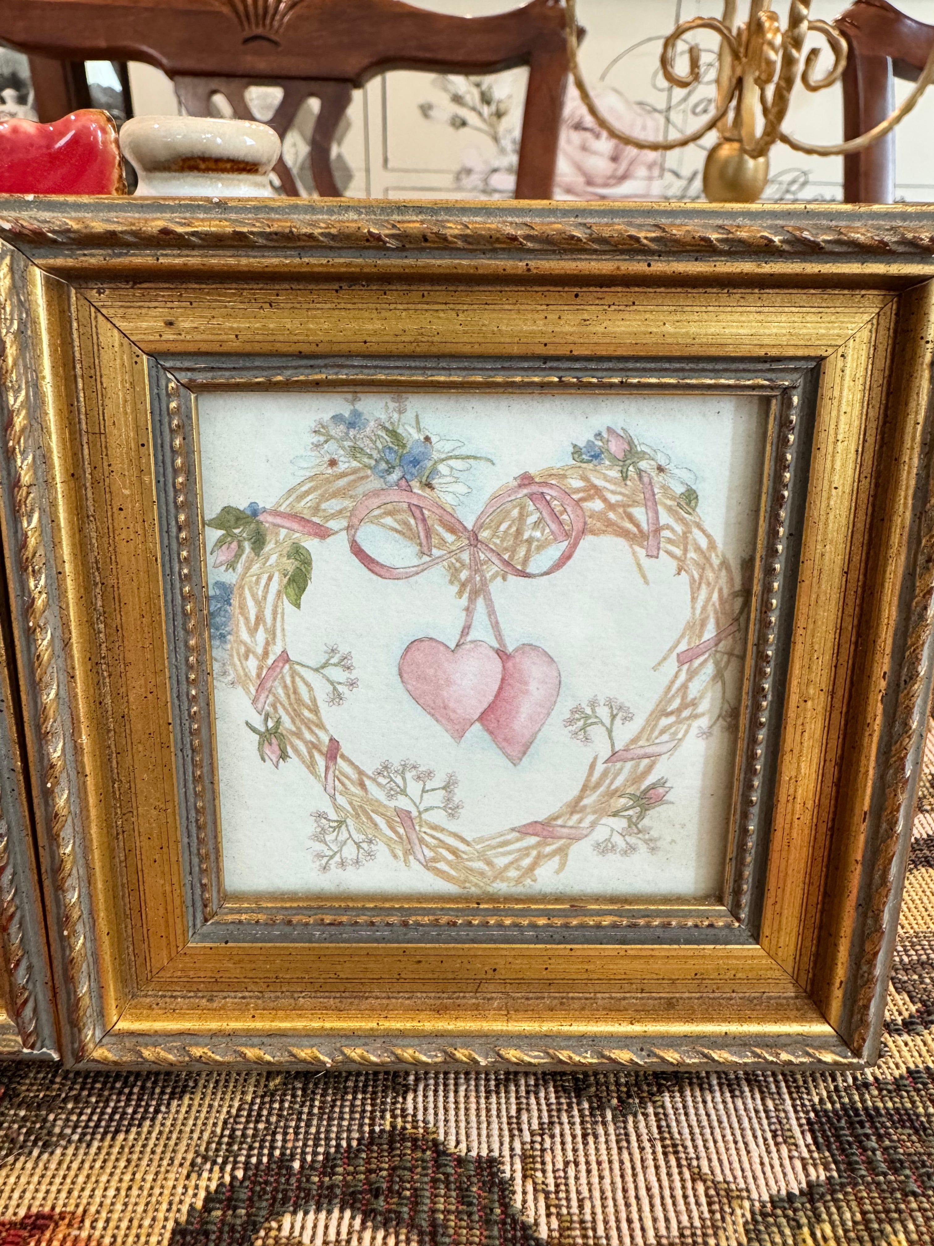 A pair of vintage framed prints by Homco with wreath and rosettes design by artist Bertrand