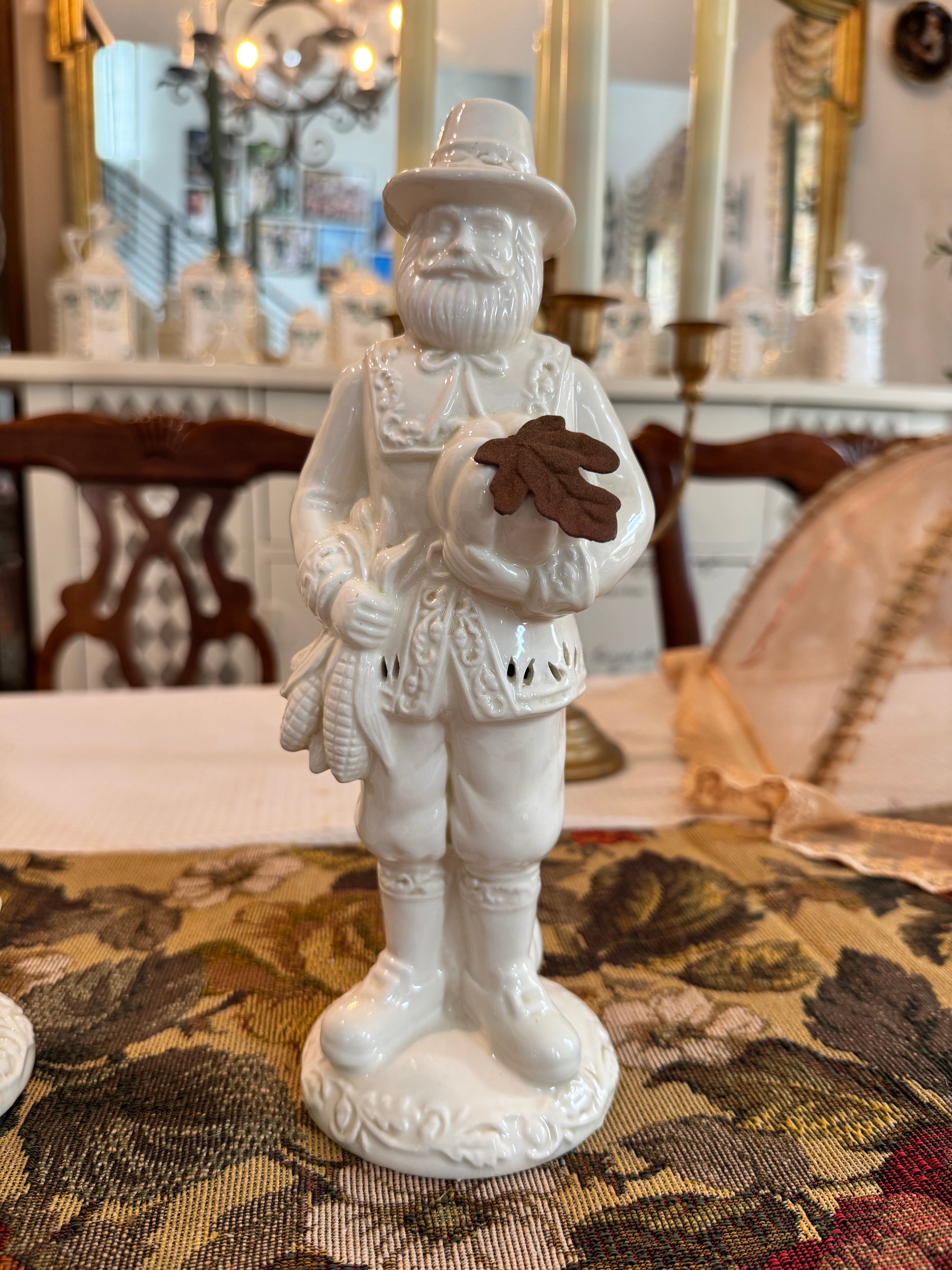 A pair of vintage white porcelain figurines depicting a Pilgrim man and woman