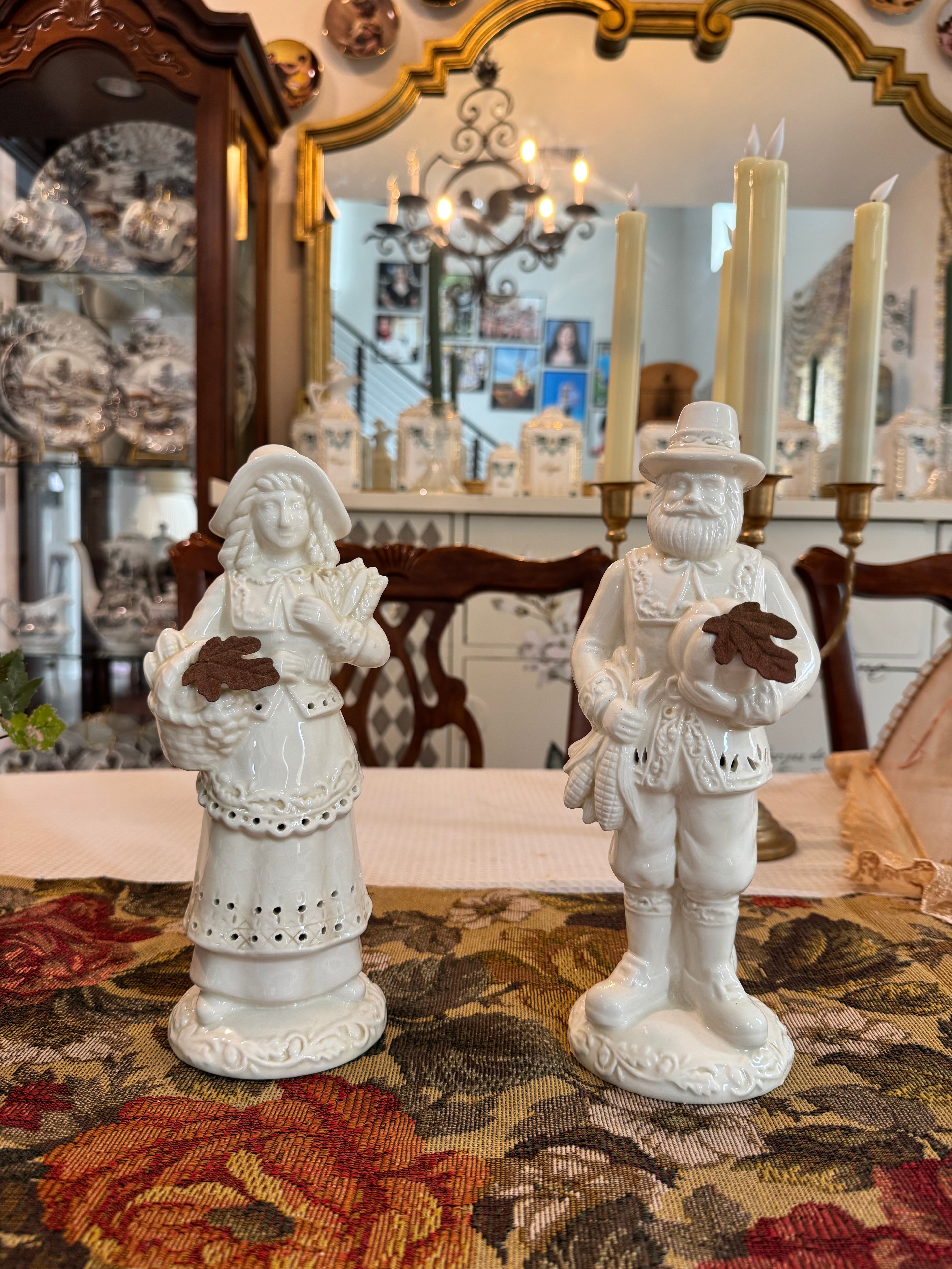 A pair of vintage white porcelain figurines depicting a Pilgrim man and woman