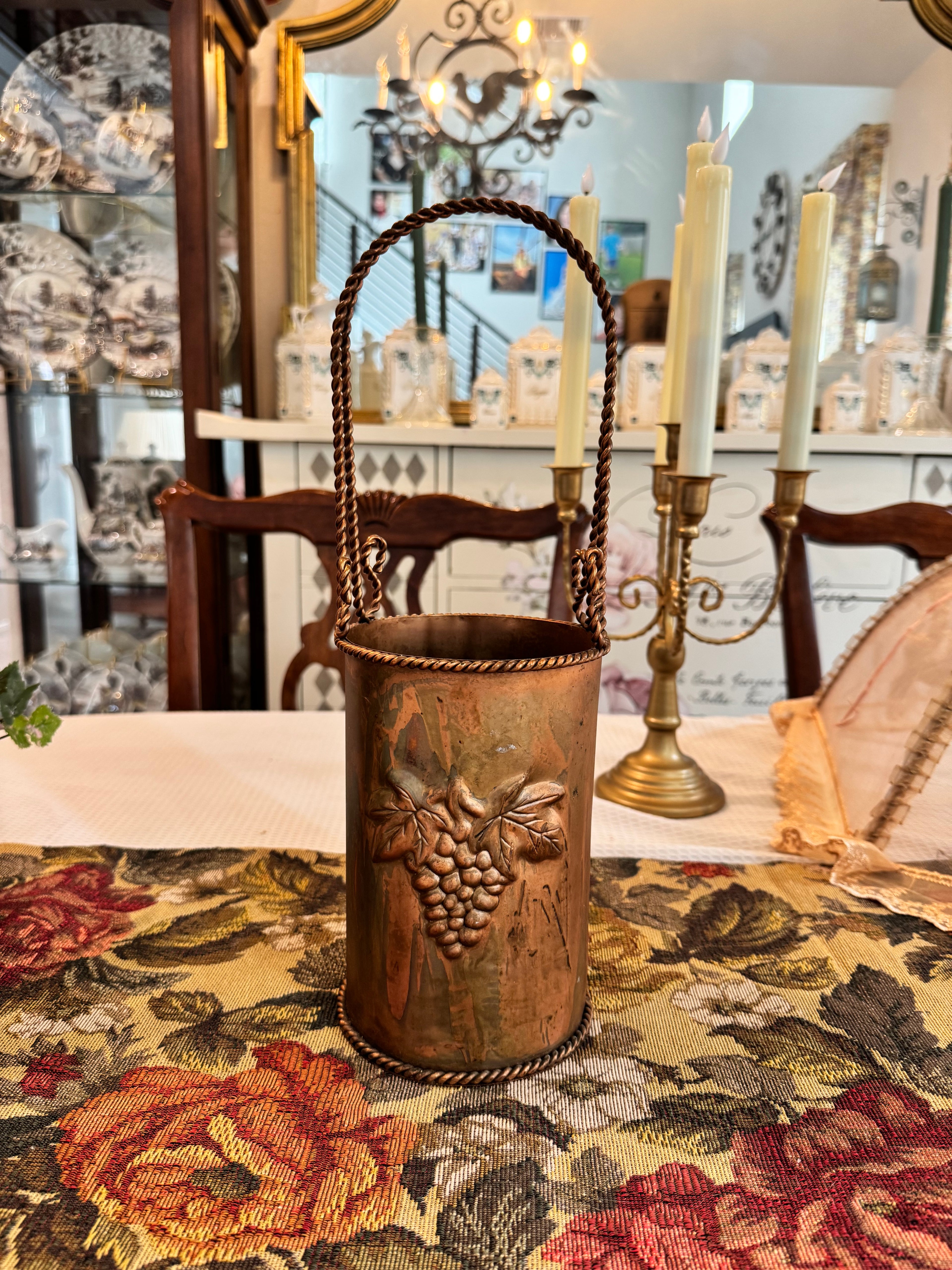 Vintage hammered copper wine or champagne cooler bucket with a twisted handle and grapevine embossing.