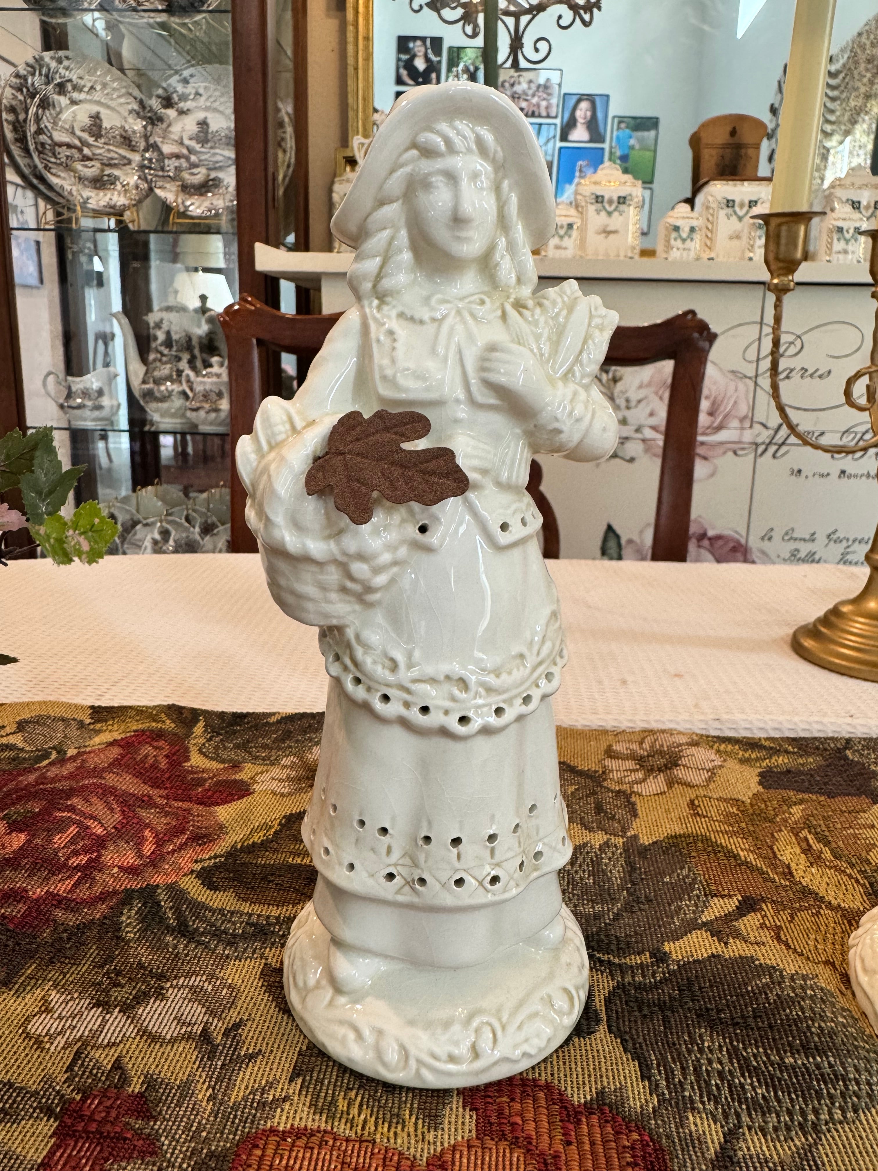 A pair of vintage white porcelain figurines depicting a Pilgrim man and woman